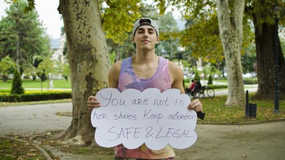 Boy holding a sign "Keep abortion safe and legal". 